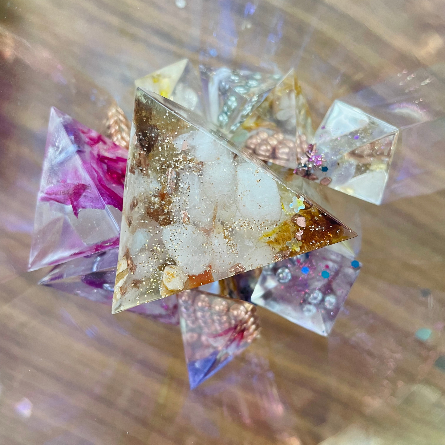 a cluster of colorful crystal organites with the gold and amber one being forward, giving off ethereal light 