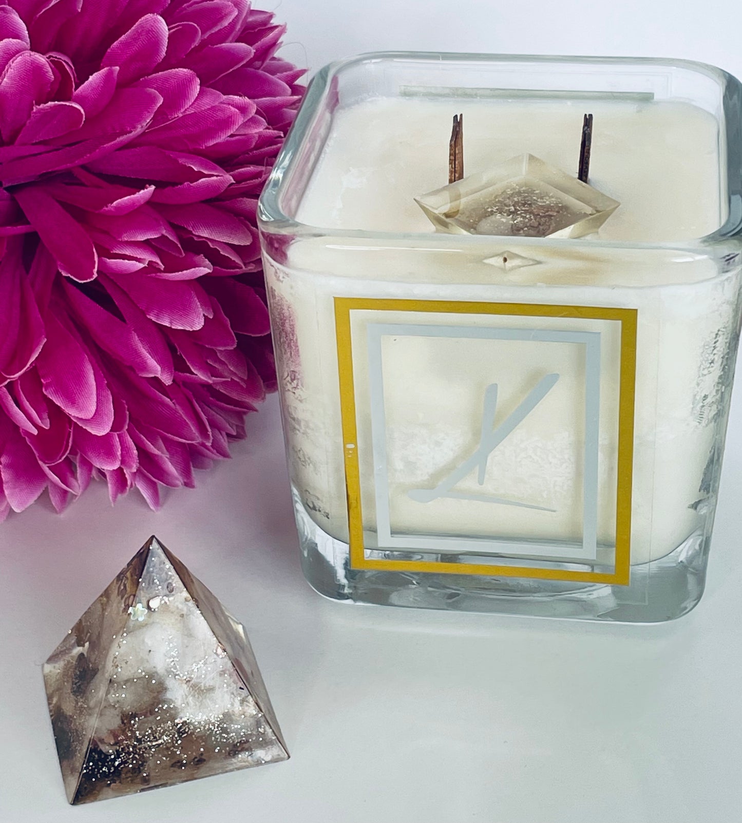 Karys Layne Candle with an organite crystal and a purple flower nearby